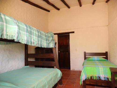 a bedroom with two bunk beds and a door at APRECUZ - Asociación Pro Recreación y Cultura de Zipaquirá in Puente Nacional