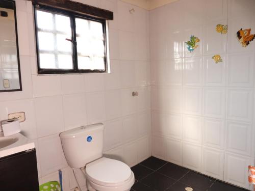 a white bathroom with a toilet and a sink at APRECUZ - Asociación Pro Recreación y Cultura de Zipaquirá in Puente Nacional