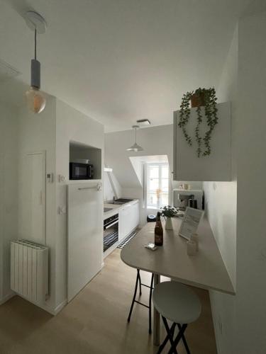 une cuisine avec une table et un comptoir dans l'établissement Studio Rive Gauche, à Dinan