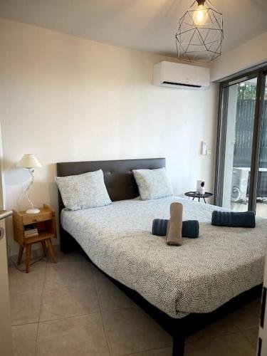 une chambre avec un grand lit avec deux oreillers dans l'établissement Le Romarin - Clim - Vue mer et Jardin - 3 Chbres, à Cassis