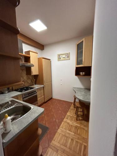 eine kleine Küche mit einem Waschbecken und einem Tisch in der Unterkunft Apartament Ludźmierska Nowy Targ in Nowy Targ