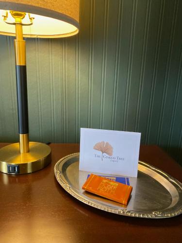 a plate with a card on a table with a lamp at The Ginkgo Tree in Mount Pleasant