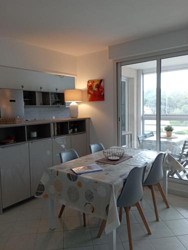 une cuisine et une salle à manger avec une table et des chaises dans l'établissement Joli T3 lumineux confortable et idéale situation, à Cavalaire-sur-Mer