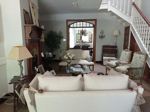 a living room with a white couch and chairs at Casona de Estilo Inglés in Montevideo