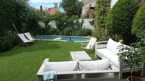 um quintal com uma piscina com duas cadeiras e um sofá em Casona de Estilo Inglés em Montevidéu