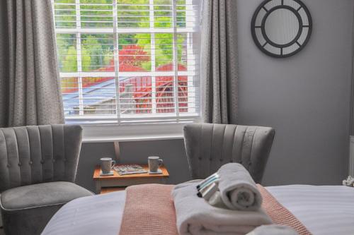a bedroom with two chairs and a bed and a window at Bridgeside Rooms in Ironbridge