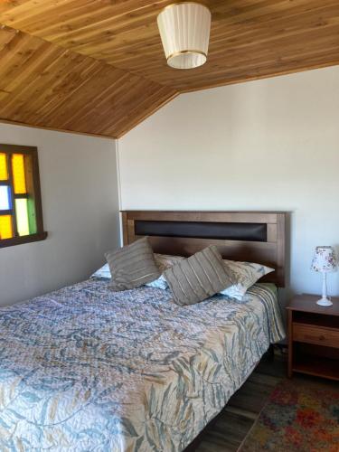 1 dormitorio con 1 cama con techo de madera en Habitación privada, vista al mar 3, en Ancud