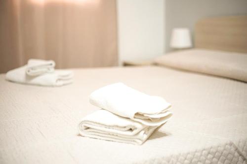 una pila de toallas sentadas encima de una cama en Rael, en Cefalú