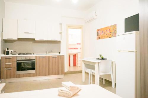 a kitchen with a table and a kitchen with white cabinets at Rael in Cefalù