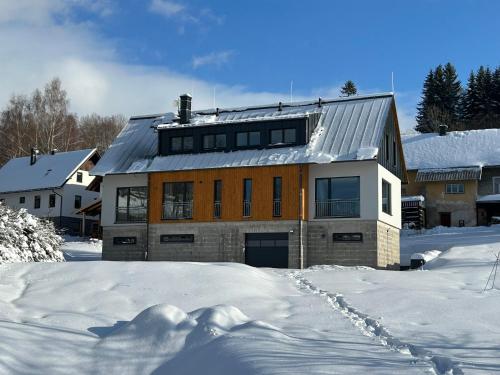 une maison dans la neige avec beaucoup de neige dans l'établissement Horský dům Vojta, à Rokytnice nad Jizerou