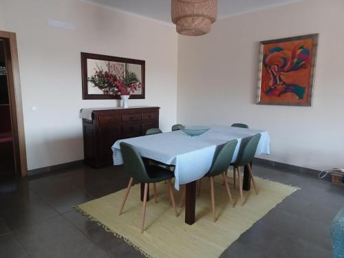 a dining room with a blue table and chairs at Casa da Praia em Porto Côvo in Porto Covo