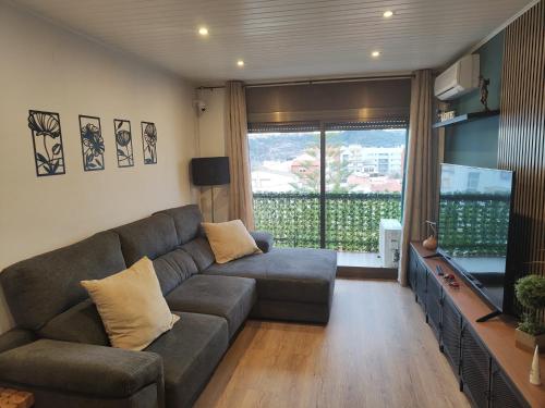 - un salon avec un canapé et une grande fenêtre dans l'établissement Habitación acogedora matrimonial, à Olesa de Montserrat
