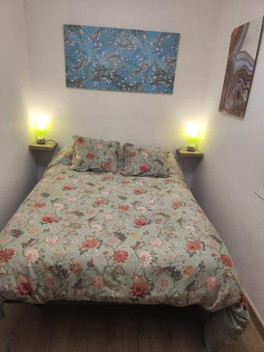 1 cama en un dormitorio con 2 lámparas en la pared en Habitación acogedora matrimonial en Olesa de Montserrat