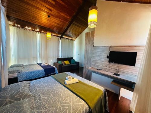 a bedroom with two beds and a flat screen tv at Village Praia dos Carneiros 3 com 6 quartos e Hidro in Tamandaré