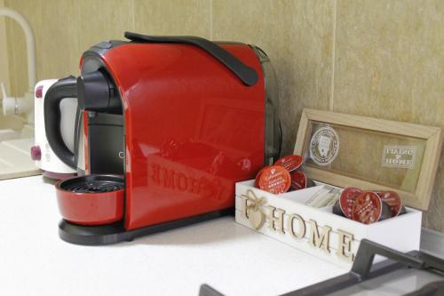 Una tostadora roja sobre un mostrador con algunos tomates. en Helia Apartment, en Galaţi