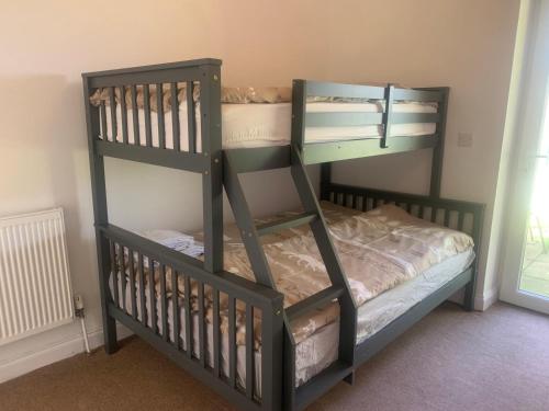 Двухъярусная кровать или двухъярусные кровати в номере Stunning Barn Conversion next to Horse Field sleeps 10