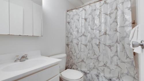 een witte badkamer met een toilet en een douchegordijn bij Corporate 1br Suite, Pool, Free Parking, Gym Pp in Harrisburg