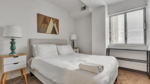 Un dormitorio blanco con una cama blanca y una ventana en Modern Corporate 2br Suite Pool, Gym Pp, en Harrisburg