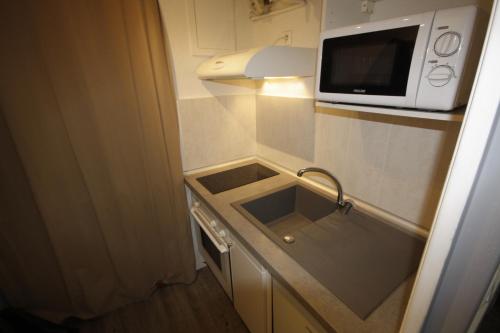 a small kitchen with a sink and a microwave at Le Beach Break - Seignosse Le Penon in Seignosse