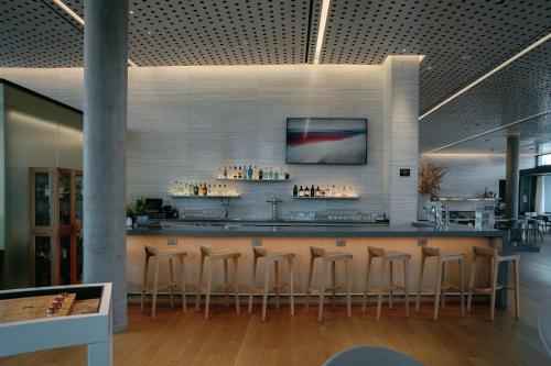 a bar in a restaurant with stools at AC Hotel by Marriott Sunnyvale Moffett Park in Sunnyvale