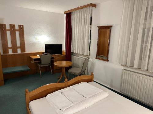Habitación hospitalaria con cama y escritorio en Hotel Sachsenhof, en Riesa