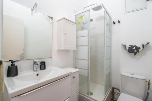 y baño blanco con lavabo y ducha. en Charmant T2 au cœur du Panier, en Marsella