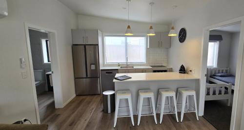 a kitchen with a counter and some stools in it at Cosy on Korari in Mangakino in Mangakino