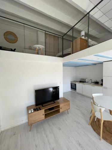 un salon avec une télévision et une table dans l'établissement Appartement coeur ville - Casa Riviera Mimosa, à Sainte-Maxime