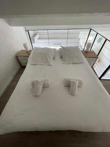 - un grand lit blanc avec trois oreillers dans l'établissement Appartement coeur ville - Casa Riviera Mimosa, à Sainte-Maxime