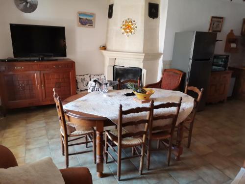 une salle à manger avec une table et des chaises et une cheminée dans l'établissement La Maison du Vent du Soleil - située au cœur de la Camargue, à Saintes-Maries-de-la-Mer