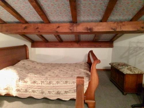 une chambre avec un lit et un banc dans l'établissement La Maison du Vent du Soleil - située au cœur de la Camargue, à Saintes-Maries-de-la-Mer