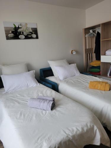two beds with towels on them in a room at Amazing apartment a stone's throw from the City of Lights - Paris in Clichy