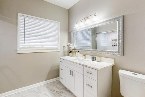 un bagno bianco con lavandino e specchio di Hello There a Corpus Christi