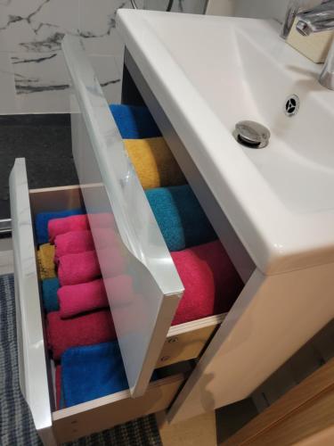 a drawer with colorful towels inside of a bathroom sink at Amazing apartment a stone's throw from the City of Lights - Paris in Clichy