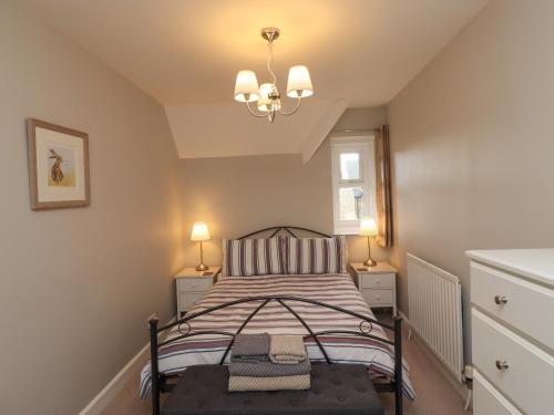 1 dormitorio pequeño con 1 cama y 2 lámparas en Jasmine Cottage, en Alnwick