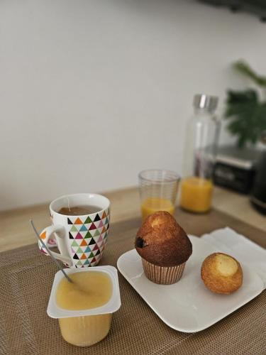 - un gâteau sur une assiette à côté d'une tasse de café dans l'établissement Chambre indépendante, privée climatisée avec parking, à Montauban