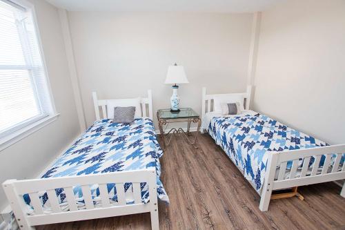 a bedroom with two beds and a table with a lamp at Oceanside, Wild Horses! Beach getaway, remote location, 4x1701, Sandy Paws Retreat in Corolla