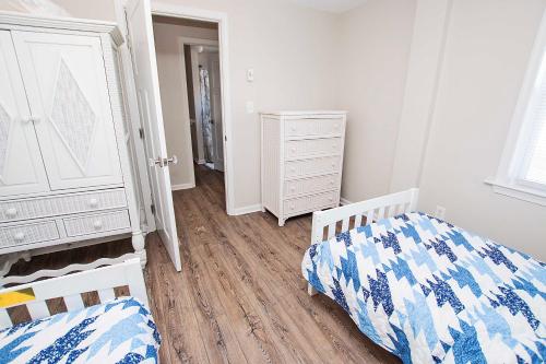 a bedroom with two beds and a dresser at Oceanside, Wild Horses! Beach getaway, remote location, 4x1701, Sandy Paws Retreat in Corolla