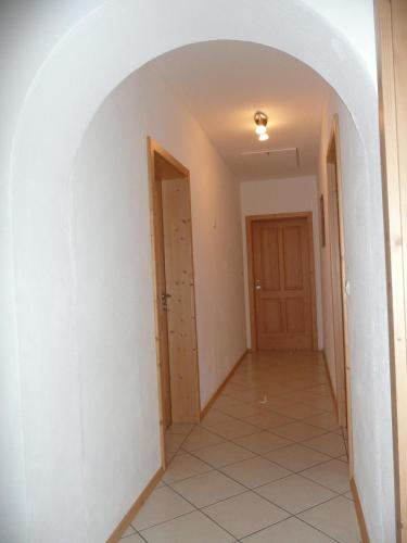 an empty hallway with an archway and a door at Landhaus Caesar - Hotel Garni in Bad Heilbrunn