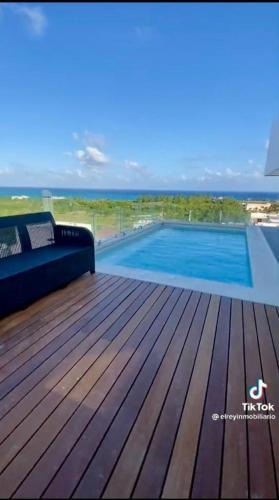 a deck with a couch and a swimming pool at Penthouse con Alberca Privada in Playa del Carmen