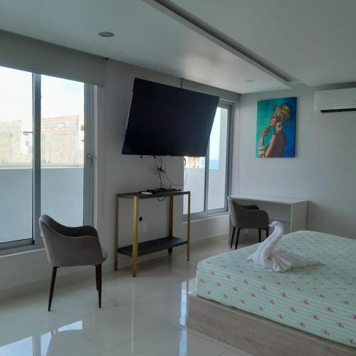 a bedroom with a bed and a flat screen tv at Penthouse con Alberca Privada in Playa del Carmen
