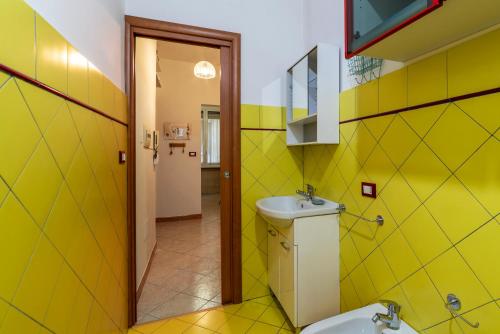 a yellow bathroom with a sink and a toilet at Piazzale delle Provincie Apartment in Rome