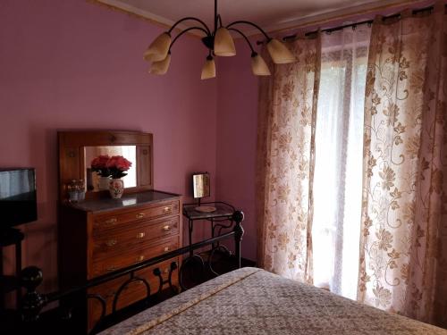 a bedroom with a bed and a dresser and a window at Guest House San Francesco Garden in Rapolano Terme