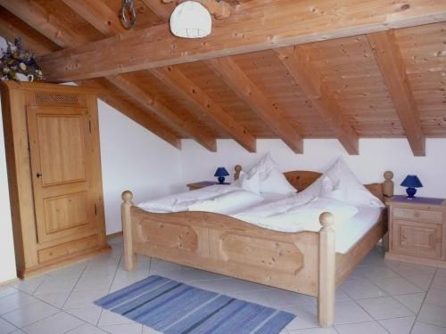 Bett in einem Zimmer mit Holzdecke in der Unterkunft Landhaus Caesar - Hotel Garni in Bad Heilbrunn