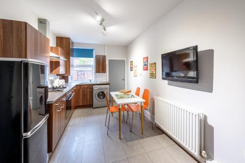 a kitchen with a table and a tv on the wall at The Scarsdale Apartment in Doncaster