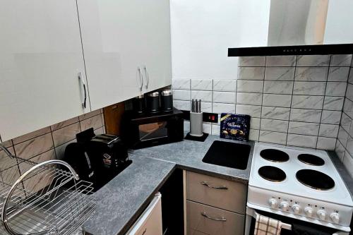 a kitchen with a stove and a counter top at Blue Sky Stays Preston in Preston