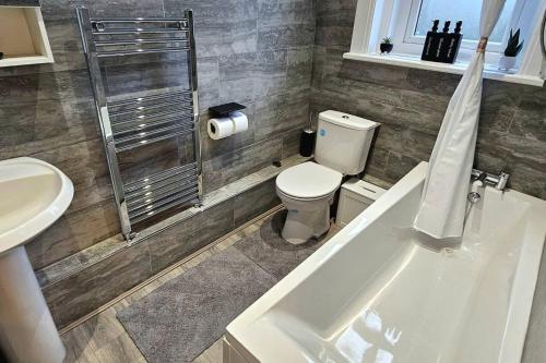 a bathroom with a toilet and a sink and a tub at Blue Sky Stays Preston in Preston