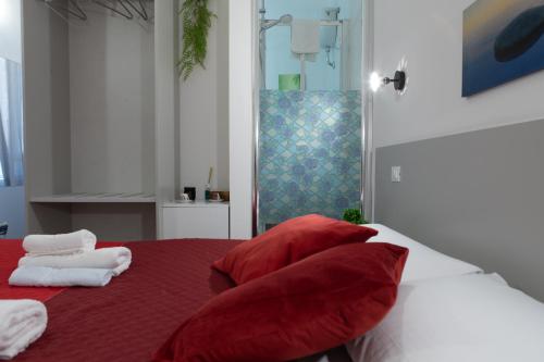 a bedroom with red and white pillows on a bed at Luxury Suite - Teatro Romano - Duomo - Centro Storico Wi-Fi in Terracina