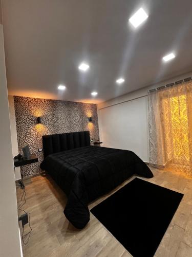 ein Schlafzimmer mit einem großen Bett mit einer schwarzen Tagesdecke in der Unterkunft B&B Zia Giuseppina & Rosa alla Riviera di Chiaia in Neapel