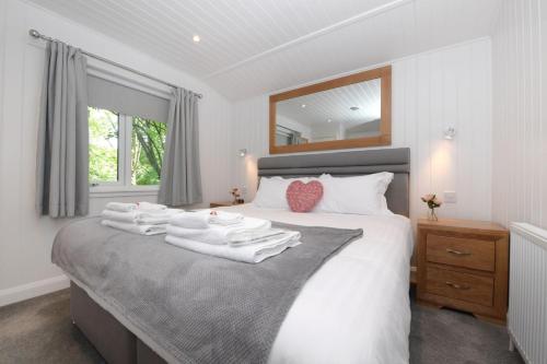 a bedroom with a bed with white towels on it at Lomond View in Langbank